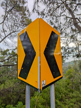 Probolinggo East Java Indonesia, 27 March 2022 - Dangerous Turn Left And Turn Right Sign, Yellow Black Road Sign Mounted On Roadside Against Blurred Background