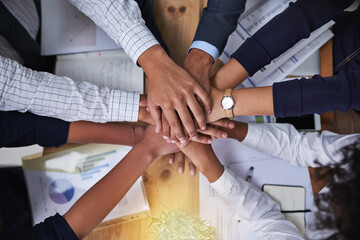 Poster - Were all in this together. High angle shot of a group of businesspeople putting their hands in a pile in the office.