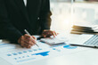 © PaeGAG - businessman working on desk office with using a calculator to calculate the numbers, finance accounting concept