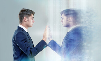 Reaching out to myself.... Cropped conceptual shot of a handsome young man reaching out to his own reflection.