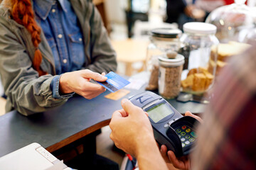 Paying made easy. Shot of a customer paying for their order with a credit card machine in a cafe.