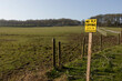 no fly tipping sign in bright yellow on the entrance to rural paddocks