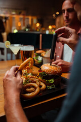 friends out for dinner eating burger and onion rings 