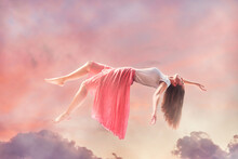 Calm Tranquil Sleeping Woman Flying In A Fairytales Dreams With Pink Clouds