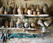 Shot of old wine jugs and farming equipment
