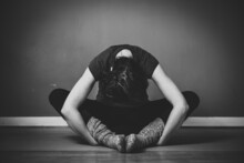 Grayscale Shot Of A Young Female Practicing Yin Yoga In A Studio