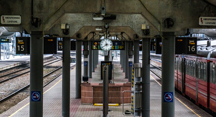 Poster - Beautiful shot of a metro station with a red train and empty metal railway and high clock