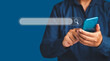 © meeboonstudio - Close-up of hand a man using a mobile phone search for information interest on search engine website while standing on a blue background