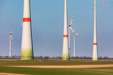 Wall Mural - Massive towers of a wind farm dominate a rural landscape in Germany while needing a mind set change towards regenerative energies in German Energiewende