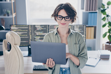 Photo of charming positive web designer hold use netbook write message daylight office indoors