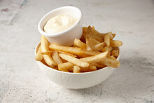 Close Up Shot Of A White Bowl Of Potato Fries With Mayo Dip