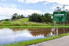 Floodwater Beside New England Highway With Road Sign