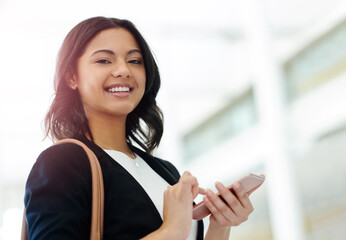 Poster - I always make sure Ive got my phone in my hand. Cropped portrait of an attractive young businesswoman smiling while using a smartphone in a modern office.