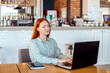© Светлана Парникова - business young woman sits at tables in a cafe and works at a laptop