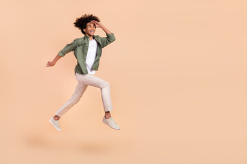 Poster - Full length body size view of attractive cheerful guy jumping running look search future isolated over beige pastel color background