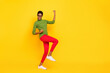 © deagreez - Photo of funky cute short hair lady dressed green turtleneck walking rising fists empty space isolated yellow color background