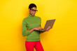 © deagreez - Photo of sweet charming trans woman wear green turtleneck typing modern device isolated yellow color background