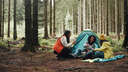 women relaxing at their campsite in the woods