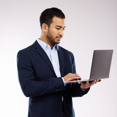 Canvas Print - Browsing the latest updates. Studio shot of a young businessman using a laptop against a white background.