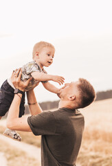 Father's day. Happy family father and toddler son playing and laughing on nature at sunset