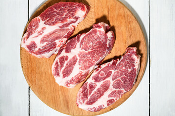 Sliced raw pork meat on wooden surface, top view