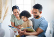 © Nicholas Felix/peopleimages.com - Teaching her some new things. Shot of a young family reading a book together at home.
