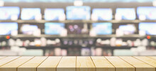 Empty Wood Table Top With Electronic Department Store Show Television TV Blurred Background