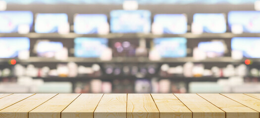 Empty wood table top with electronic department store show Television TV blurred background