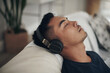 © Jeff Bergen/peopleimages.com - When my headphones are in, the world is blocked out. Shot of a young man using headphones at home.