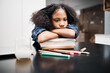 © Micah C/peopleimages.com - I wish I had a study buddy. Shot of a young girl looking unhappy while doing a school assignment at home.
