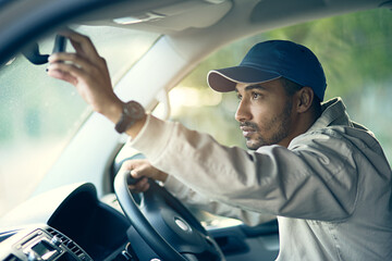 Aufkleber - Off to make his next delivery stop. Cropped shot of a delivery man adjusting the rear-view mirror of his van.
