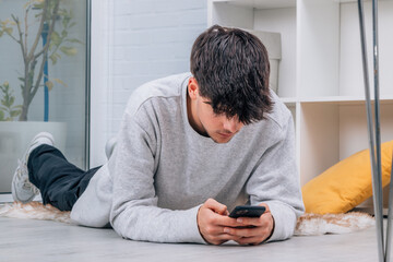 Wall Mural - young man with mobile phone at home