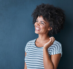 Making happiness a priority. Studio shot of an attractive and happy young woman posing against a blue background.