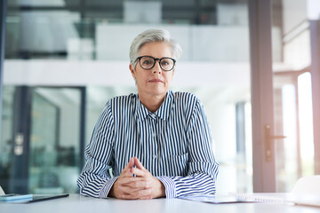 Lets get down to business. Portrait of an attractive mature businesswoman sitting at her office desk at work.