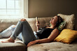 © Chanelle Malambo/peopleimages.com - When words are few music says a lot. Shot of a young woman using a smartphone and headphones on the sofa at home.