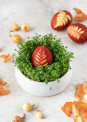 easter egg with pattern leaves in a traditional rustic style in cress nest. homemade food and decora