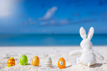 Easter Travel Concept With A Bunny And Colorful Eggs Sitting In The Sand On A Tropical Paradise Beach