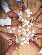 © Nikish H/peopleimages.com - This team isnt easily puzzled. High angle shot of a group of unidentifiable businesspeople building a puzzle together in the office.