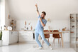 © Pixel-Shot - Cool young man dancing and singing at home