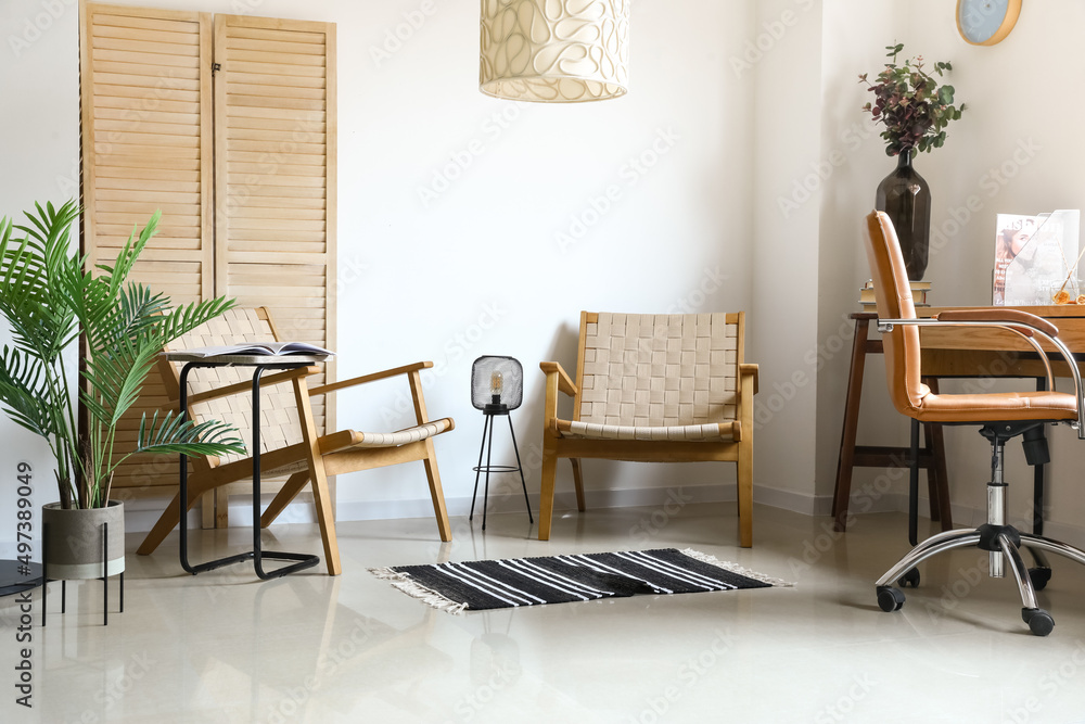 Stylish armchairs in interior of light room