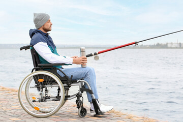 Canvas Print - Man in wheelchair fishing on river