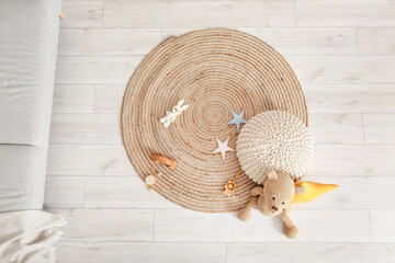 Wall Mural - Wicker carpet with pouf and toys in children's room