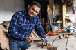 © Fernanda - Hispanic carpenter nailing into wood - worker man with carpentry tools - man hammering
