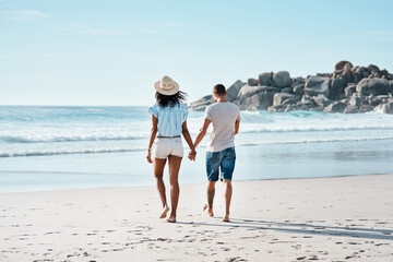 Sticker - Love ebbs and flows like the tides. Rearview shot of a young couple walking along the beach.