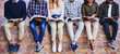 © Nikish H/peopleimages.com - Studying on campus. Cropped shot of a group of unrecognizable university students studying while sitting outside on a facebrick wall.