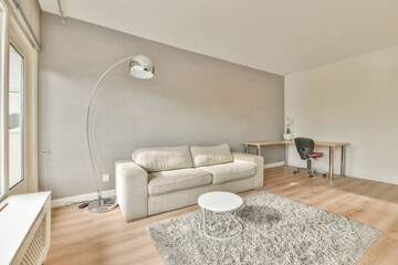 Wall Mural - A spacious living room with a terry carpet on the floor and a sofa next to the window in a modern apartment