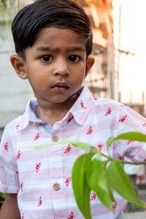 Wall Mural - A boy is seen through the frame of a rusty iron rod. Boy's beautiful closeup face on a beautiful afternoon.