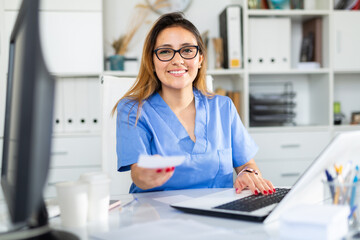 Wall Mural - Colombian female doctor is giving recipe to client in hospital