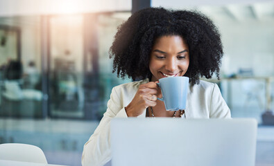 Poster - Theres nothing like a cup of coffee to keep you going. Shot of a young businesswoman having a cup of coffee while doing some work at her office desk.