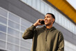 © Nikola Spasenoski - young african american man in casual outfit standing and talking on phone